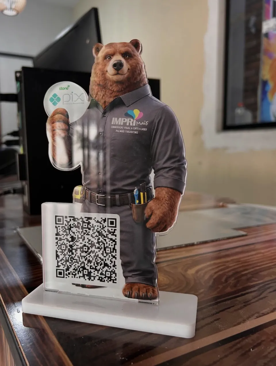 Display de acrílico cortado a laser com o urso mascote da Imprimais e QR code de Pix