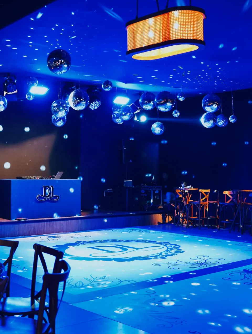 Pista de dança adesivada com monograma sob luzes azuis