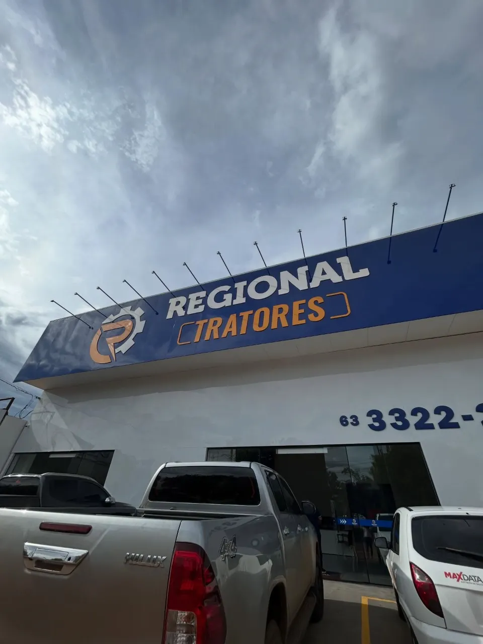Fachada da Regional Tratores com letra caixa branca e laranja sobre painel azul