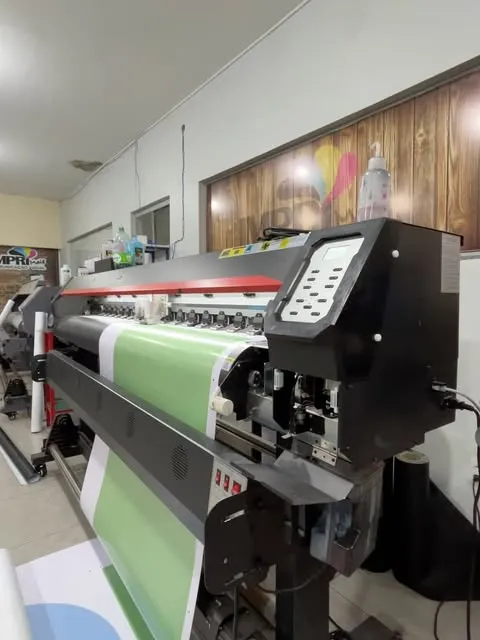 Impressora de adesivo e lona com rolo verde em produção