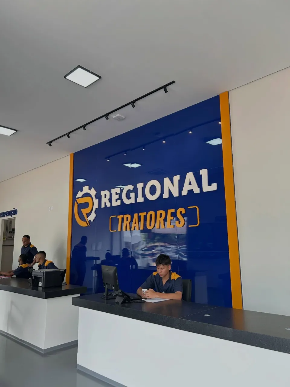 Recepção da Regional Tratores com painel azul e logo em letra caixa